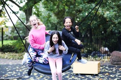Girls playing on swing at Whitehorse adventure playground