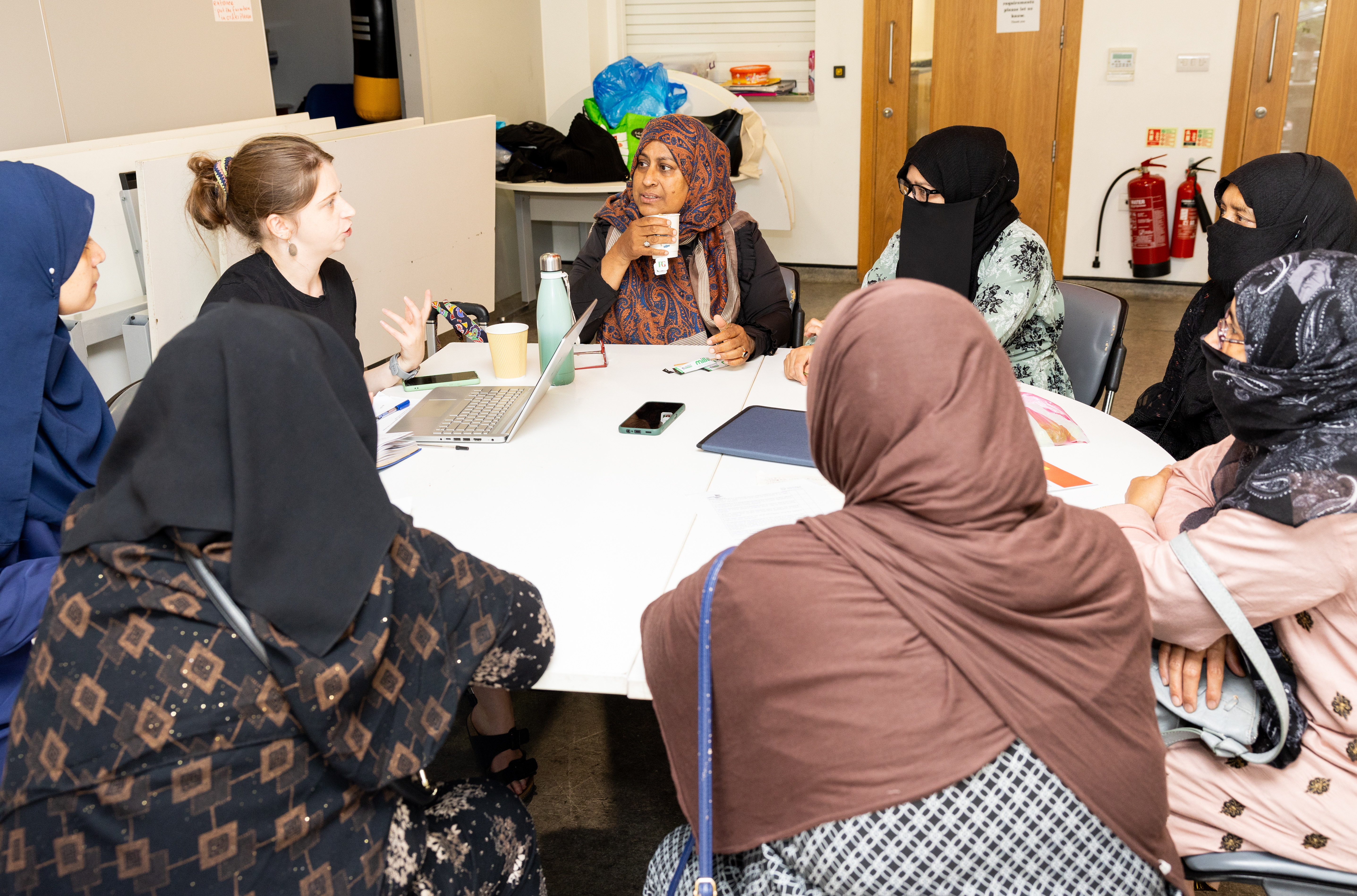 Researcher speaking to a group of hijab and niqab wearing women