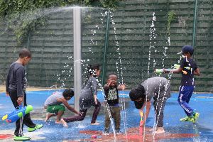 Kids playing in the sprinkler fountain